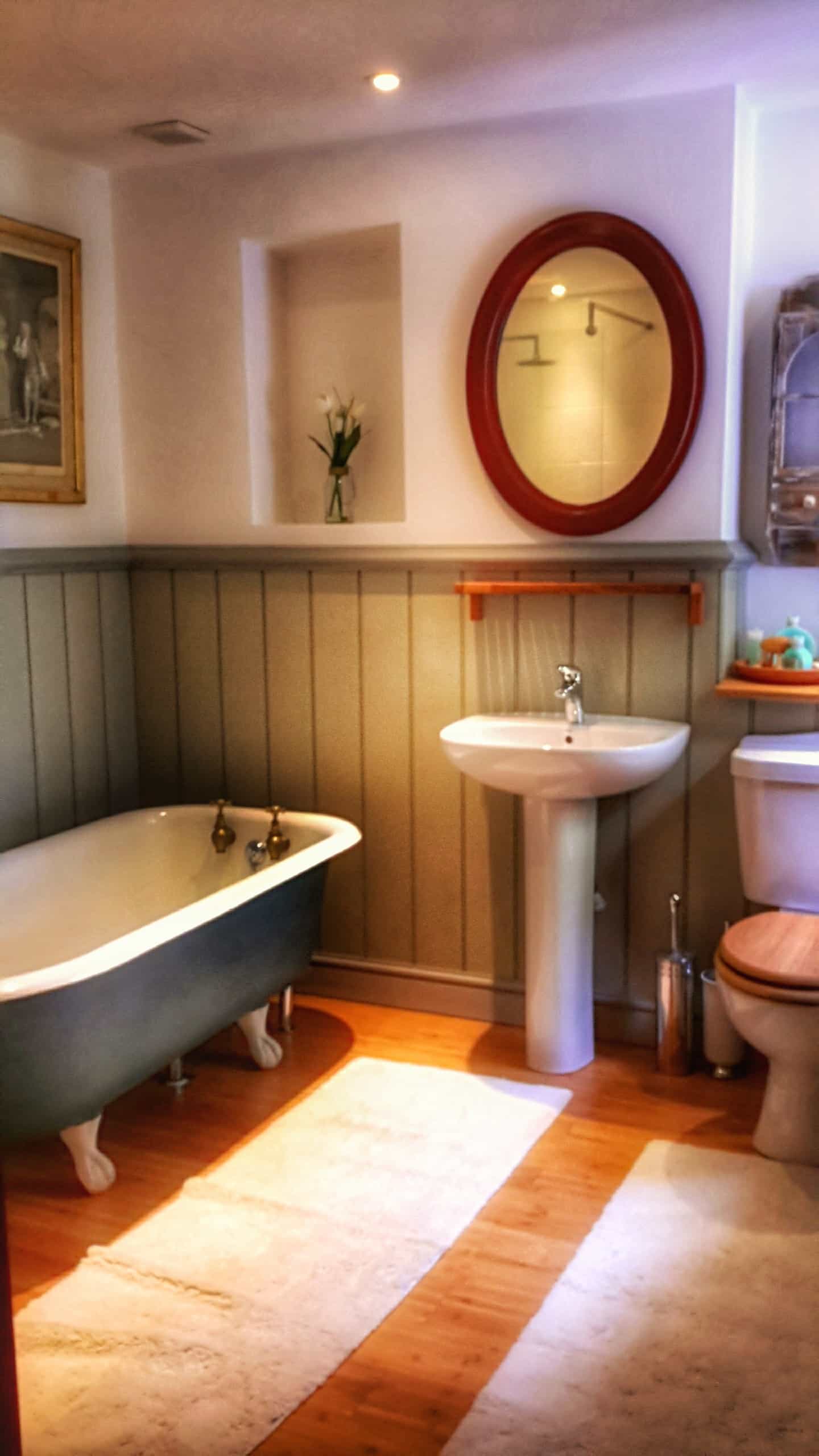 private bathroom with shower and cast iron bath tub